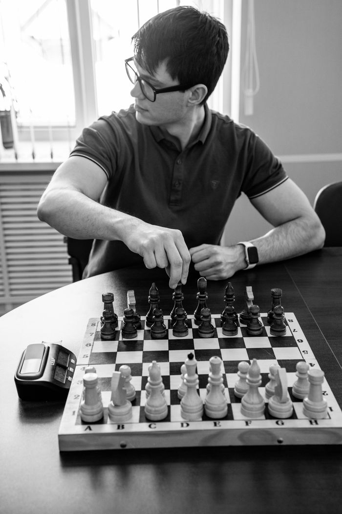 Black and white image of a man playing chess, demonstrating strategic thinking.