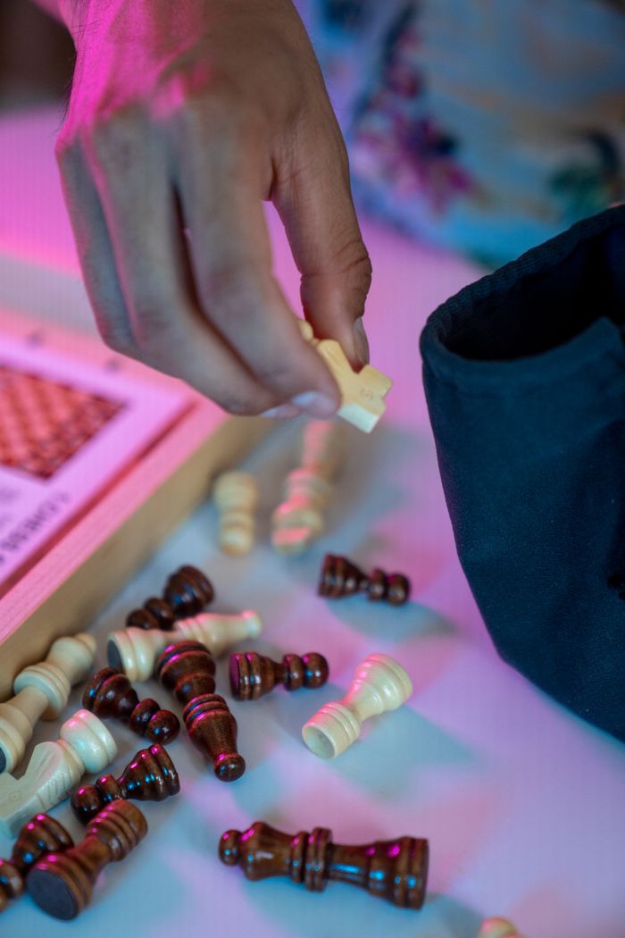 Home A hand carefully places chess pieces on a board, showcasing strategy and focus.